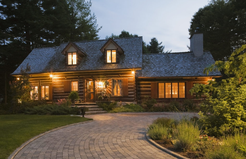Reconstructed 1976 cottage style log home facade at dusk, Quebec, Canada